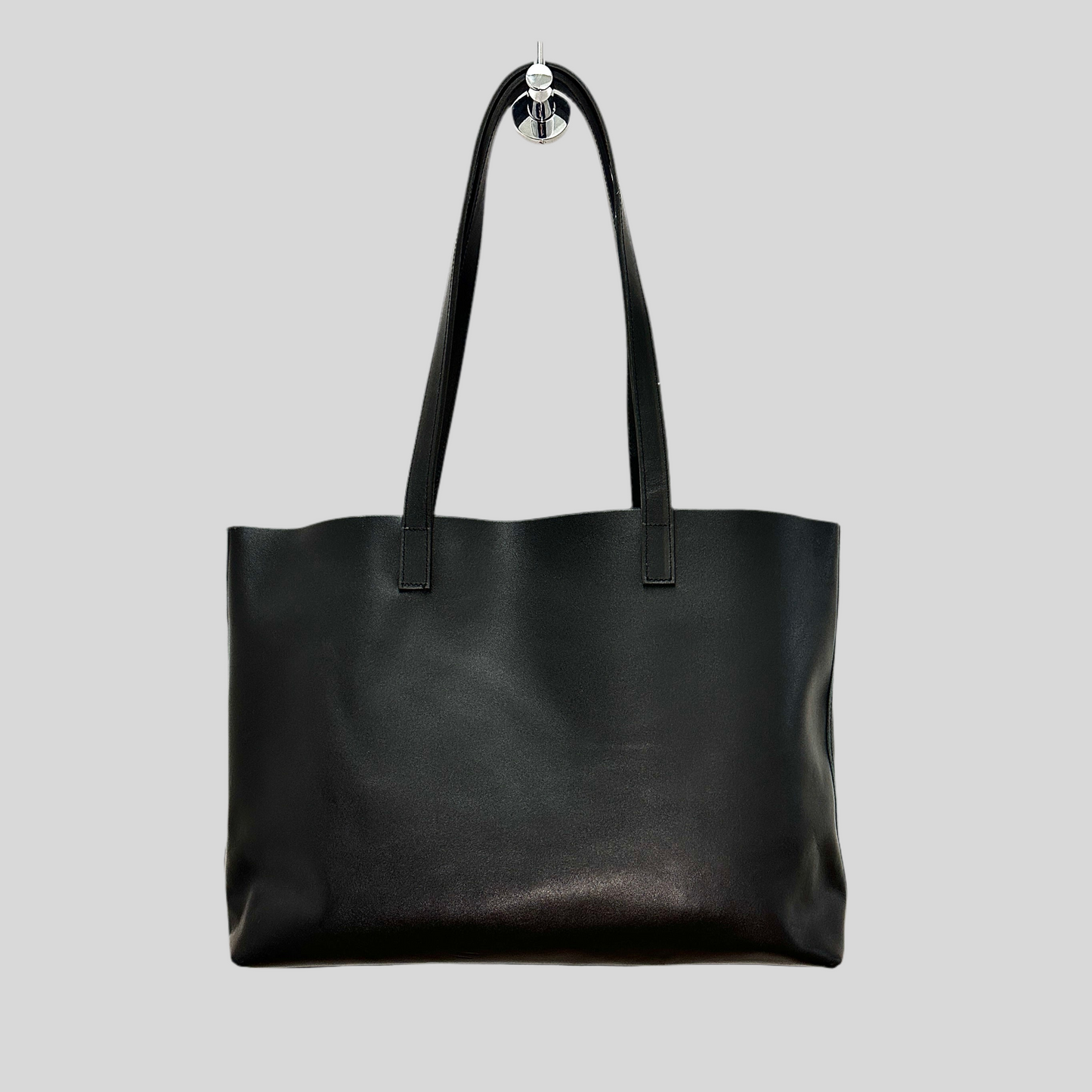 Handmade black leather tote bag styled over a shoulder with casual outfit, highlighting everyday use.