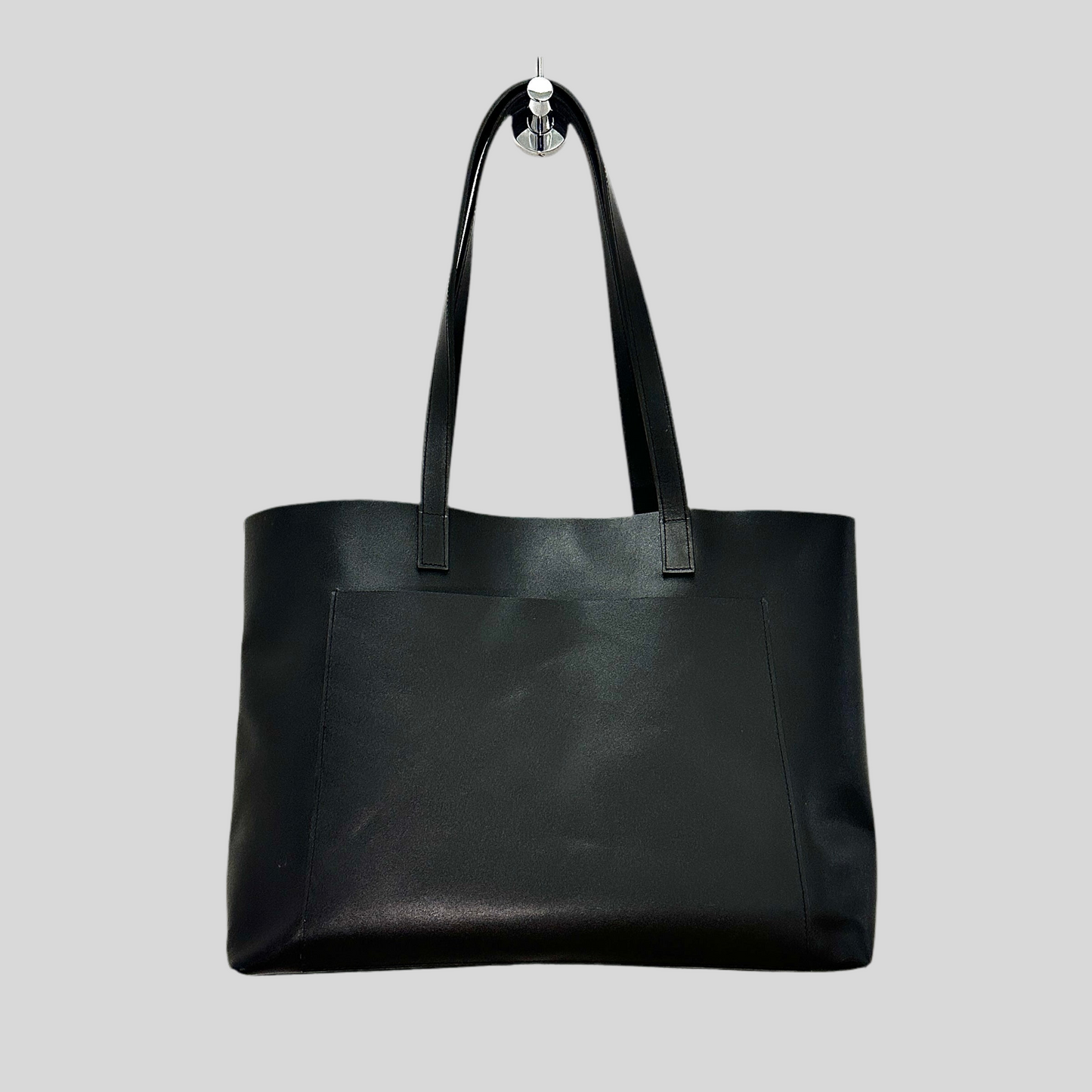 Handmade black leather tote bag styled over a shoulder with casual outfit, highlighting everyday use.