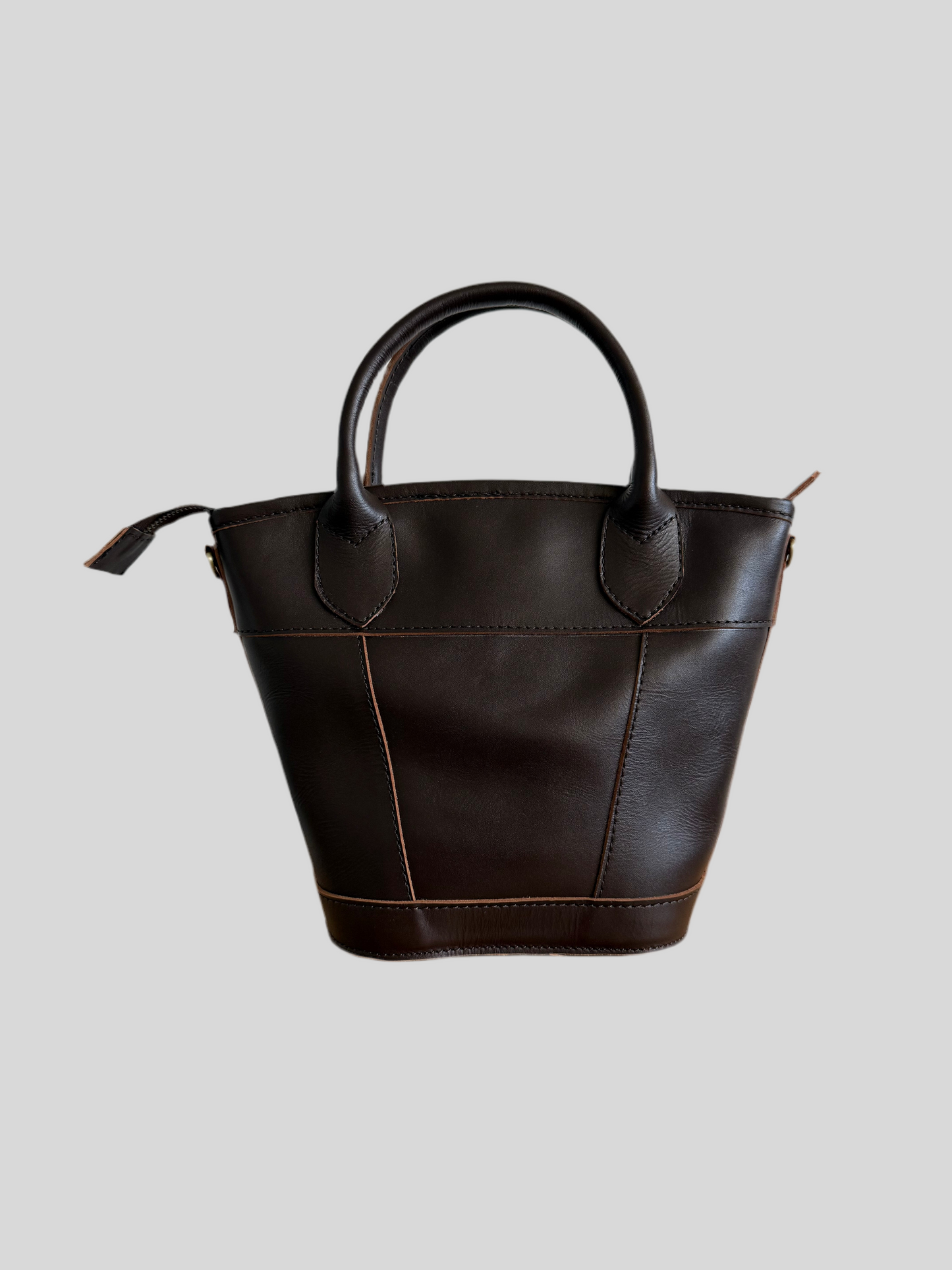 Brown Florence mini leather handbag with top handles and crossbody strap, styled on a neutral background.
