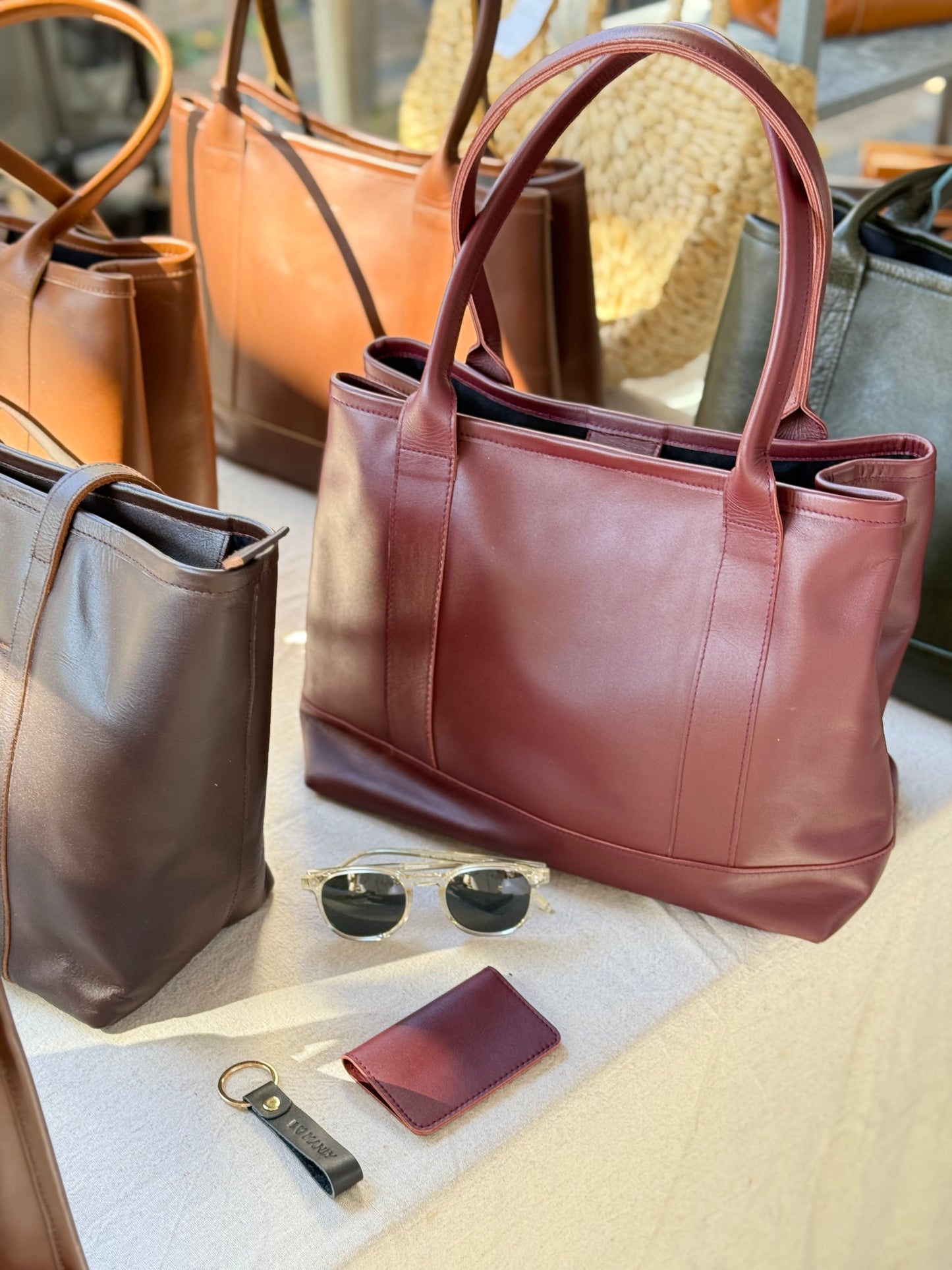 Handmade burgundy leather tote bag with high-quality genuine leather, interior zippered pockets, and adjustable shoulder straps. Spacious enough for a 13-inch laptop, perfect for work or daily use.